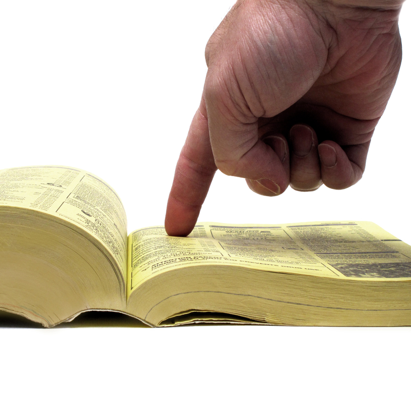 finger pointing to an entry in the yellow pages